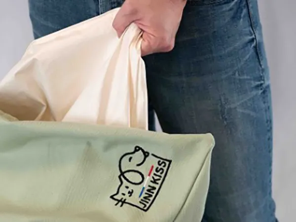 Coussin pour chat déhoussable dont on retire la housse pour la mettre en machine à laver, montrant l'élimination des odeurs et du sébum incrusté.